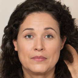 Joyful white adult female with long  brown hair and brown eyes