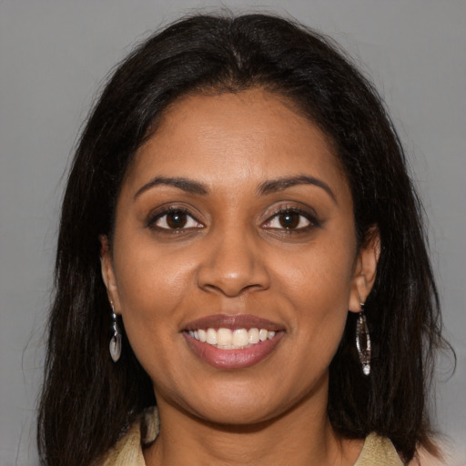 Joyful black young-adult female with long  brown hair and brown eyes