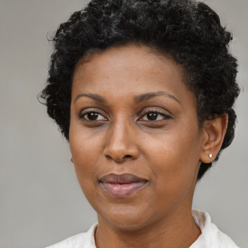Joyful black adult female with short  black hair and brown eyes
