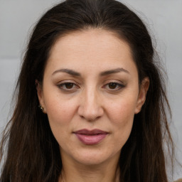 Joyful white adult female with long  brown hair and brown eyes