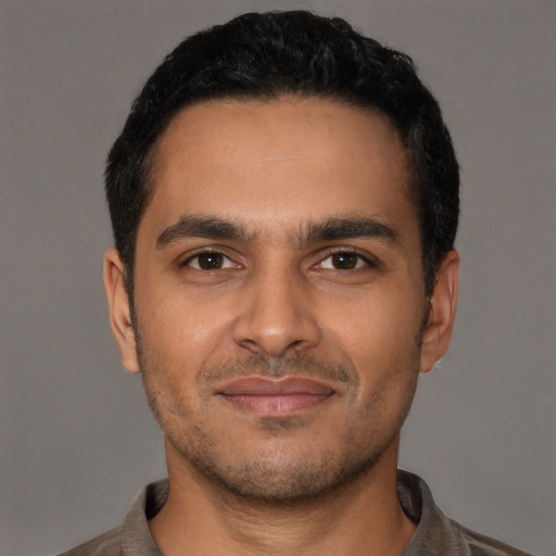 Joyful latino young-adult male with short  black hair and brown eyes