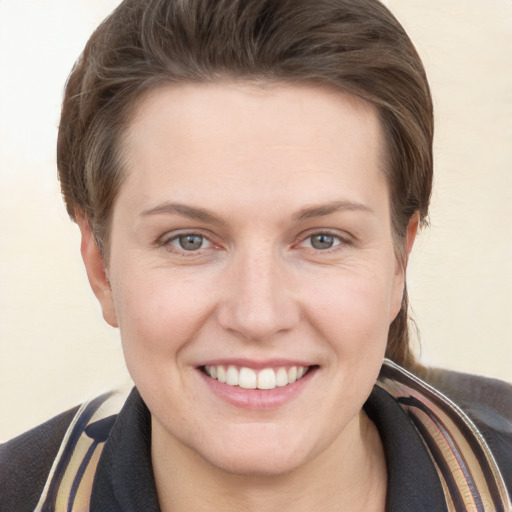 Joyful white young-adult female with short  brown hair and grey eyes