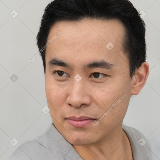 Joyful asian young-adult male with short  brown hair and brown eyes