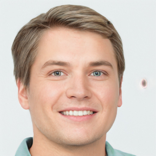 Joyful white young-adult male with short  brown hair and grey eyes