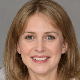 Joyful white young-adult female with medium  brown hair and blue eyes