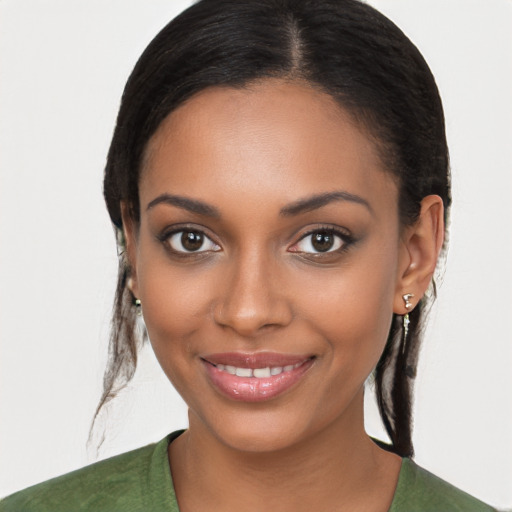 Joyful black young-adult female with long  brown hair and brown eyes