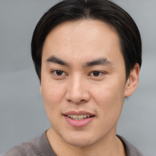 Joyful asian young-adult male with short  brown hair and brown eyes