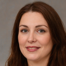 Joyful white adult female with long  brown hair and brown eyes