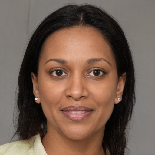 Joyful black young-adult female with long  brown hair and brown eyes