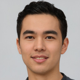 Joyful asian young-adult male with short  black hair and brown eyes