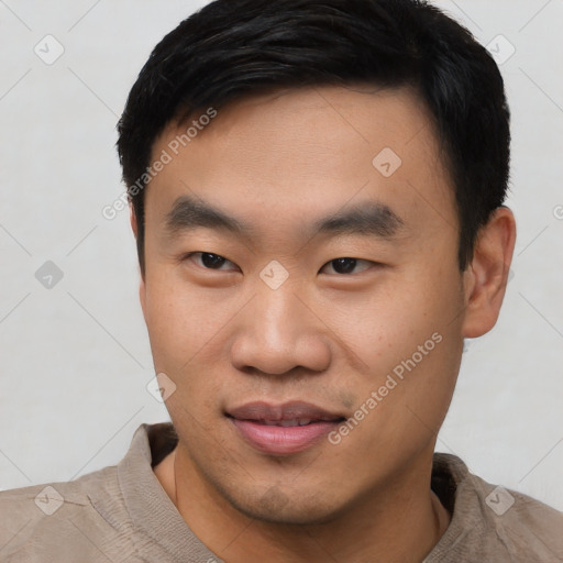 Joyful asian young-adult male with short  black hair and brown eyes