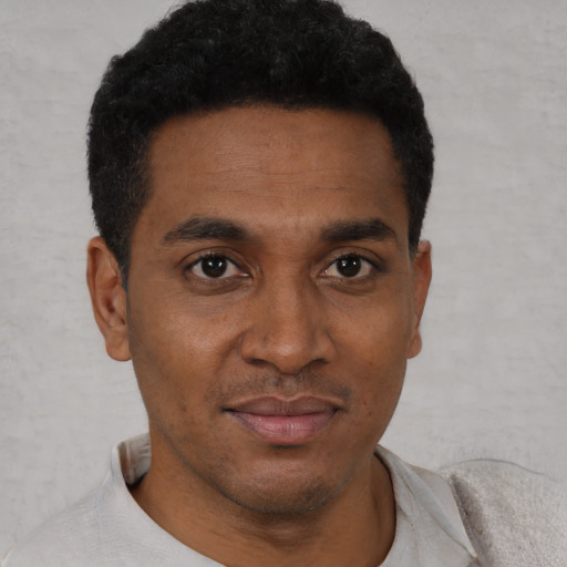 Joyful black young-adult male with short  black hair and brown eyes