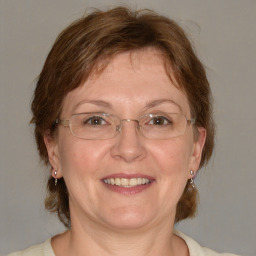 Joyful white adult female with medium  brown hair and blue eyes