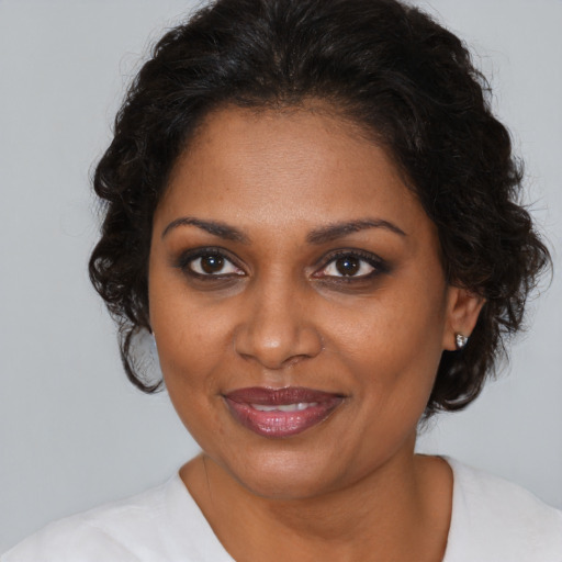 Joyful black young-adult female with medium  brown hair and brown eyes