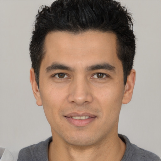 Joyful white young-adult male with short  black hair and brown eyes