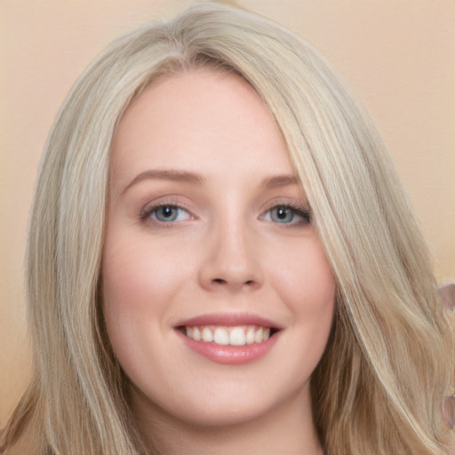 Joyful white young-adult female with long  blond hair and grey eyes