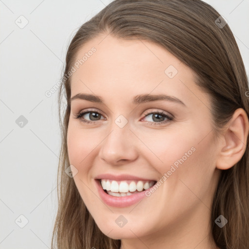 Joyful white young-adult female with long  brown hair and grey eyes