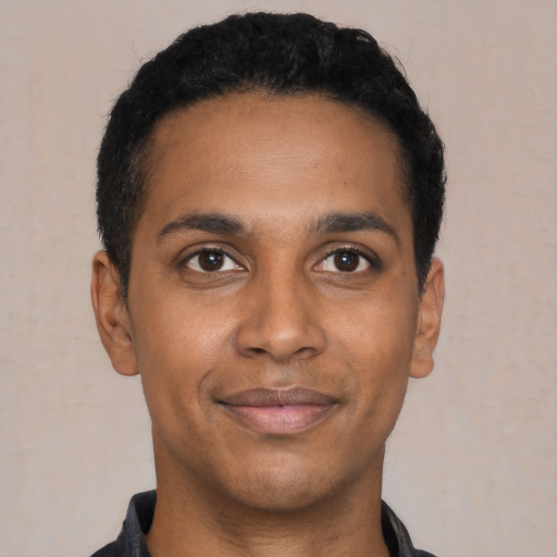 Joyful black young-adult male with short  black hair and brown eyes