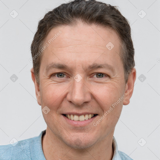 Joyful white adult male with short  brown hair and grey eyes