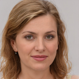 Joyful white young-adult female with long  brown hair and green eyes