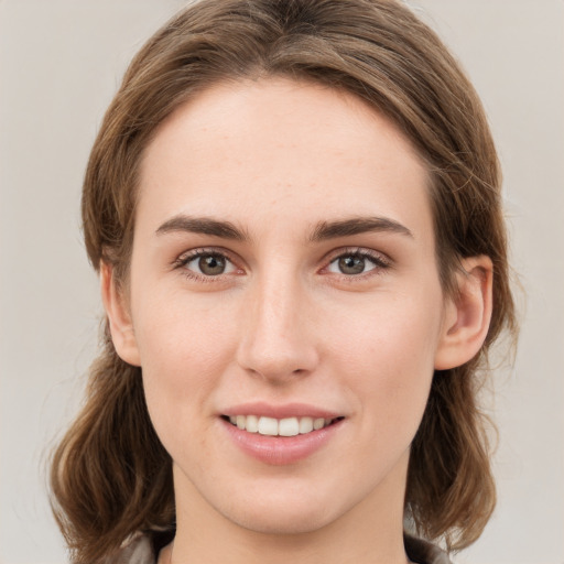 Joyful white young-adult female with medium  brown hair and green eyes