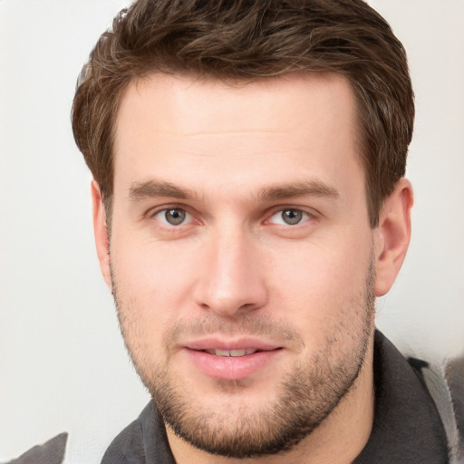 Joyful white young-adult male with short  brown hair and grey eyes