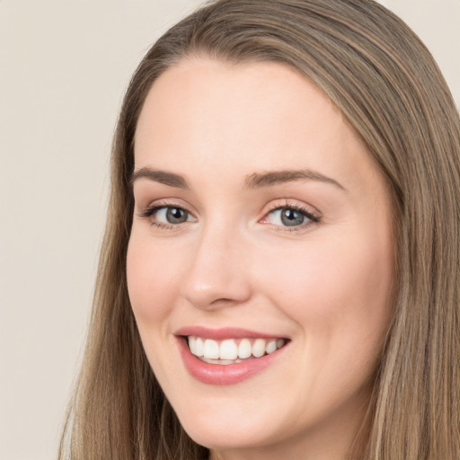 Joyful white young-adult female with long  brown hair and grey eyes