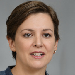 Joyful white young-adult female with medium  brown hair and grey eyes