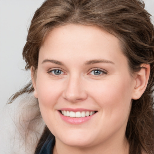 Joyful white young-adult female with medium  brown hair and blue eyes