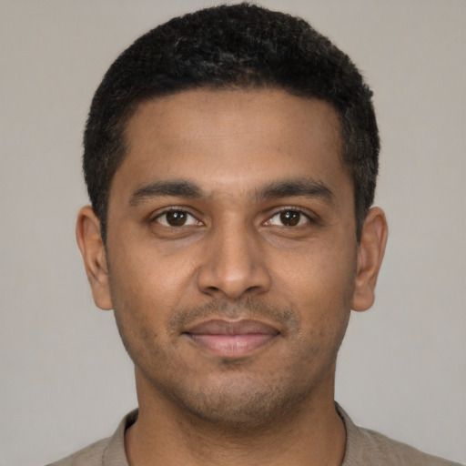 Joyful black young-adult male with short  black hair and brown eyes
