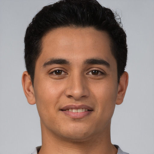 Joyful latino young-adult male with short  brown hair and brown eyes