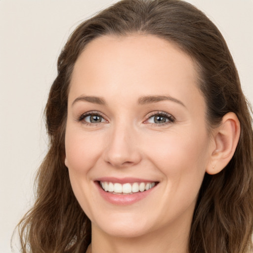 Joyful white young-adult female with long  brown hair and blue eyes