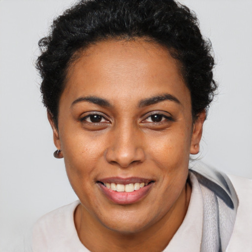 Joyful latino young-adult female with short  brown hair and brown eyes