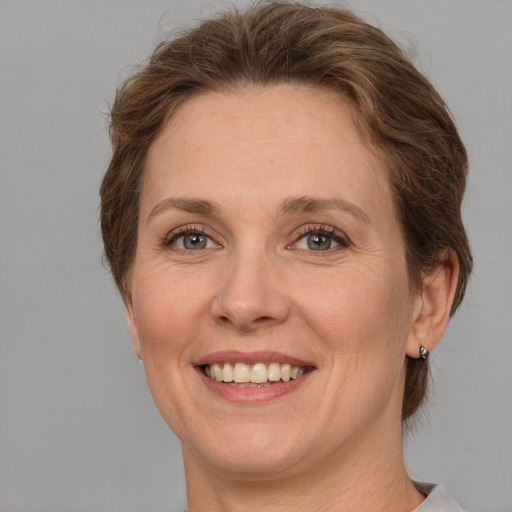 Joyful white adult female with medium  brown hair and grey eyes