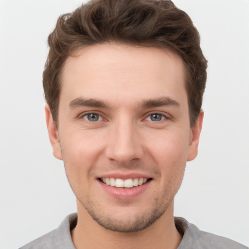 Joyful white young-adult male with short  brown hair and grey eyes