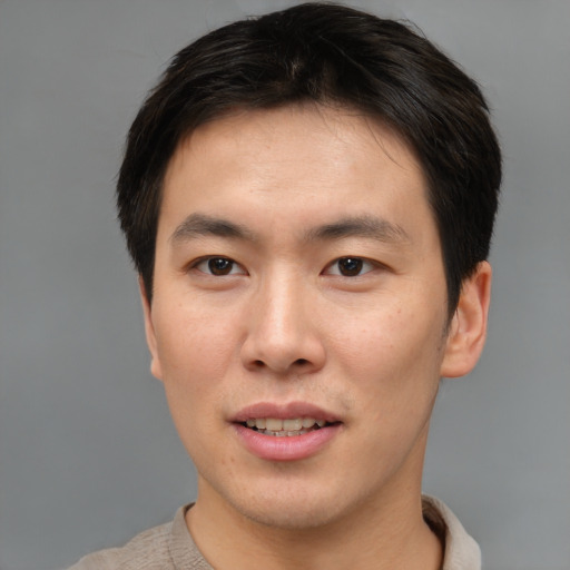 Joyful asian young-adult male with short  brown hair and brown eyes
