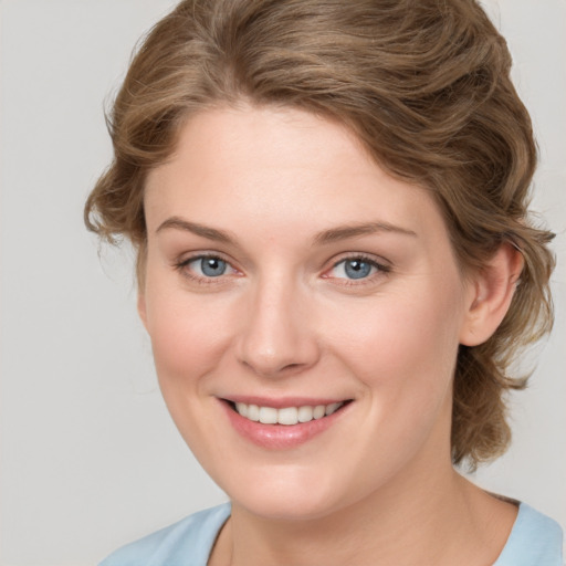 Joyful white young-adult female with medium  brown hair and blue eyes