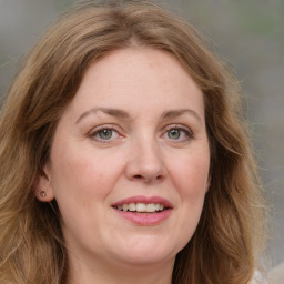 Joyful white adult female with long  brown hair and green eyes