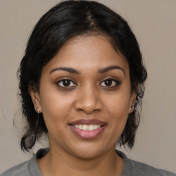 Joyful black young-adult female with medium  brown hair and brown eyes