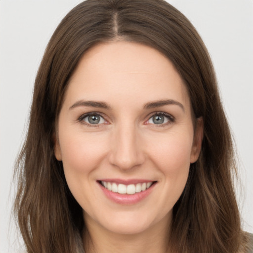 Joyful white young-adult female with long  brown hair and brown eyes