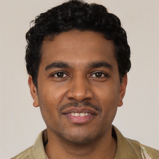 Joyful black young-adult male with short  black hair and brown eyes