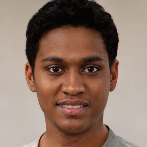 Joyful black young-adult male with short  black hair and brown eyes
