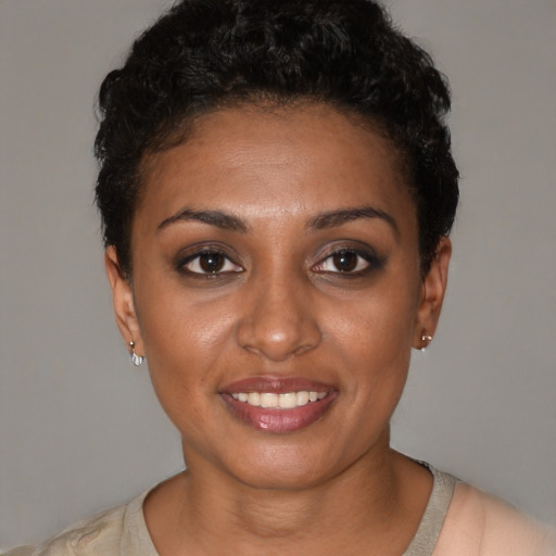 Joyful black young-adult female with short  black hair and brown eyes