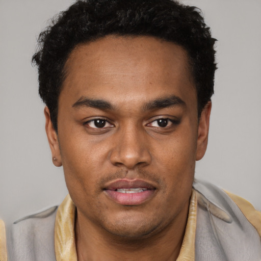 Joyful black young-adult male with short  brown hair and brown eyes