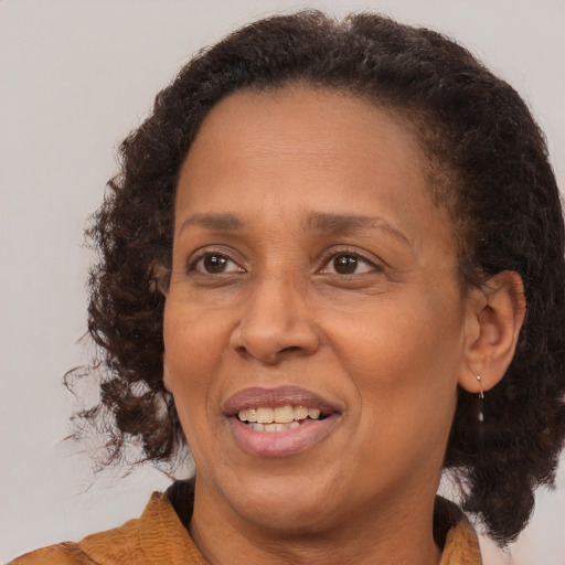 Joyful black adult female with medium  brown hair and brown eyes