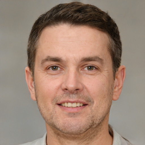 Joyful white adult male with short  brown hair and brown eyes