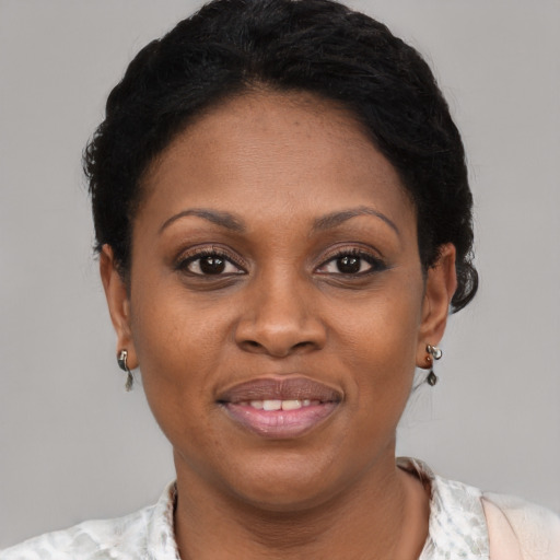 Joyful black young-adult female with short  black hair and brown eyes