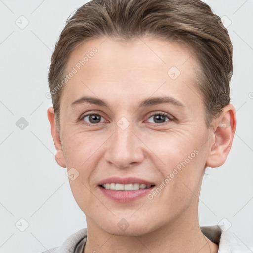 Joyful white young-adult female with short  brown hair and grey eyes