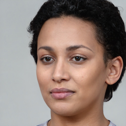 Joyful black young-adult female with short  black hair and brown eyes