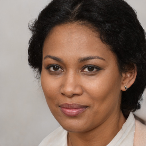 Joyful black young-adult female with medium  brown hair and brown eyes